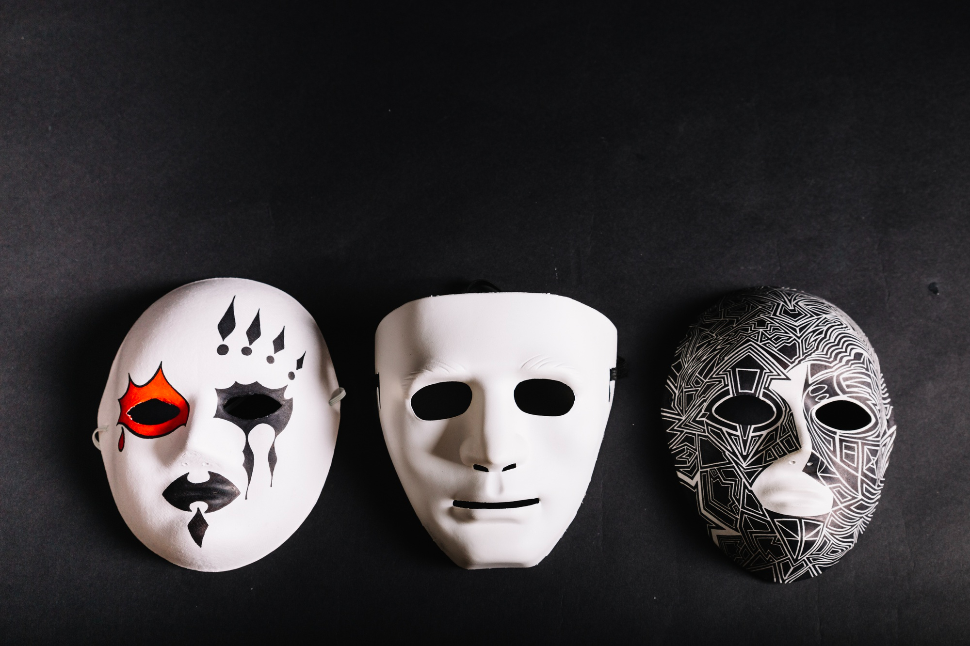 Three unique Jigsaw Masks showcasing detailed designs in white, black, and red.